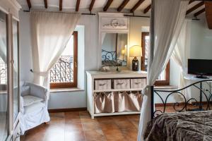 a bedroom with a bed and a mirror and a chair at Anna Camere in Montalcino +21 photos
