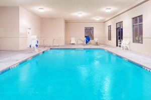 a swimming pool with blue water in a building at Super 8 by Wyndham Columbia East in Columbia