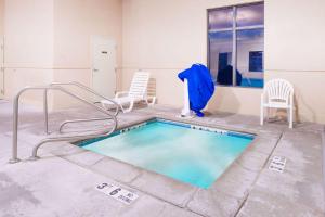 a swimming pool with chairs and a blue jacket on it at Super 8 by Wyndham Columbia East in Columbia