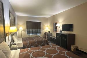 ein Hotelzimmer mit zwei Betten und einem Flachbildfernseher in der Unterkunft Super 8 by Wyndham Columbia East in Columbia