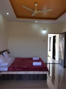 a bedroom with a bed with a ceiling fan at Gugal Residency Mahabaleshwar in Mahabaleshwar