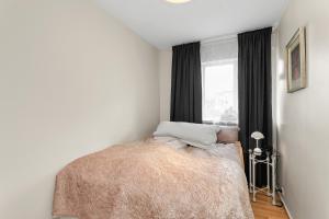 1 dormitorio con cama y ventana en Cozy and Quiet 2BR Apartment, en Reikiavik