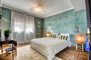 a bedroom with a bed and a desk and a window at Dafa Splendide Riad Agadir résidentiel 8 or 9 Px in Agadir