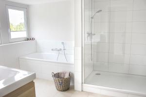 a white bathroom with a tub and a shower at Deichkind im Deichhaus in Husum