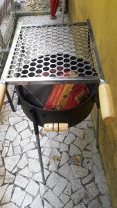 a grill sitting on a stone floor next to a wall at Loft dos Vagalumes in Boicucanga
