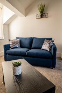 a blue couch in a living room with a table at Merton rd serviced accommodation in Walton on the Hill