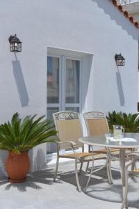 a white table and chairs on a patio with a table at Oisyra Boutique Suites in Ermoupoli