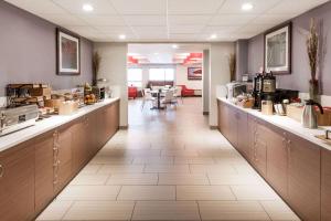 una cafetería con un largo pasillo con cocina y mesa en Microtel Inn & Suites by Wyndham Fort Saint John, en Fort Saint John