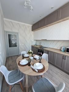 a kitchen with a table and chairs in a room at 2-х комнатные апартаменты in Taldykolʼ