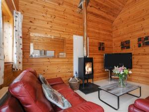 sala de estar con sofá de cuero y chimenea en Polzeath, en Bodmin