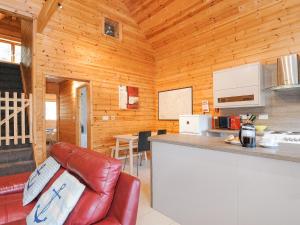 a kitchen with a counter and a red leather chair at Polzeath in Bodmin