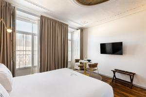 a hotel room with a bed and a tv at LP Heritage Apartments By Sé Apartamentos in Braga