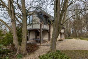 una casa con un porche al lado de ella en Charmante Chaumière Romantique, en Biéville-en-Auge
