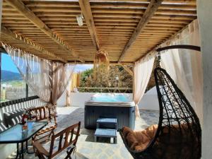 a porch with a hammock and a table and chairs at Janakos Luxury Apartment in Glinado Naxos