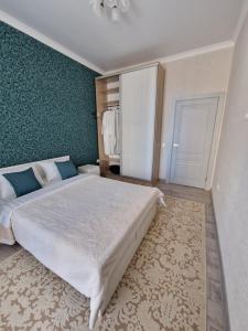 a bedroom with a large bed and a green wall at 2-х комнатные апартаменты in Taldykolʼ