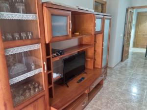 a large wooden entertainment center with a television in it at San Ramón centro Benicarló in Benicarló