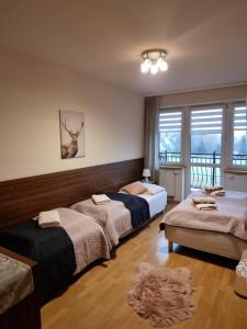 a bedroom with two beds and a balcony at Villa Broniewskiego in Zakopane