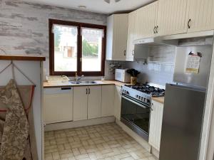a kitchen with white cabinets and a stove top oven at MAISON 3 CHAMBRES SUR UNE DUNE A 50 M DE LA PLAGE in La Tranche-sur-Mer
