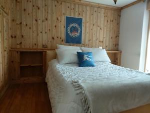 1 dormitorio con 1 cama grande y paredes de madera en APPARTAMENTO CORTINA 1956, en Cortina dʼAmpezzo