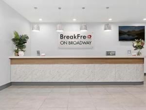 a sign that reads breakfast on broadway above a counter at BreakFree on Broadway Sydney, an Accor Hotel in Sydney