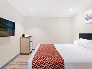 a bedroom with a bed and a tv on a wall at BreakFree on Broadway Sydney, an Accor Hotel in Sydney