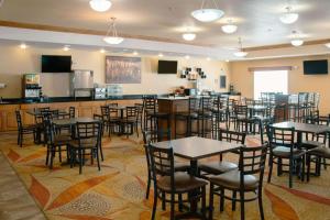 un restaurante con mesas y sillas y un bar en Grand Forks Lodge and Suites, en Grand Forks