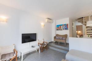 sala de estar con TV de pantalla plana y sofá en Apartamento Ferrera Park 103, en Cala d´Or