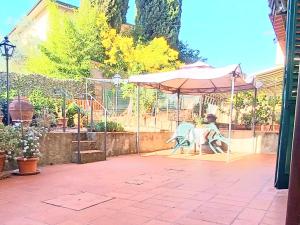 une personne assise sous un parasol sur une terrasse dans l'établissement Casa Chianti, à Mercatale Val Di Pesa