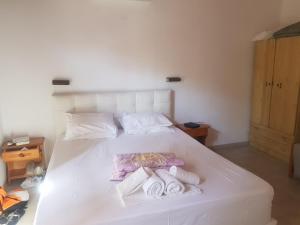 sypialnia z białym łóżkiem i ręcznikami w obiekcie Kaiti Villa 4 w mieście Koukounaries