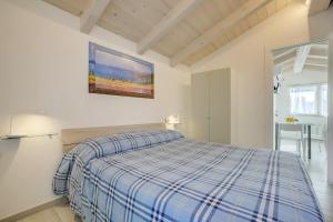 ein Schlafzimmer mit einem Bett mit einer blauen karierten Decke in der Unterkunft Baita Marina - Tramontana 30m mare in Ceriale
