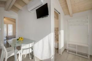 ein Esszimmer mit einem Tisch und einem TV an der Wand in der Unterkunft Baita Marina - Tramontana 30m mare in Ceriale