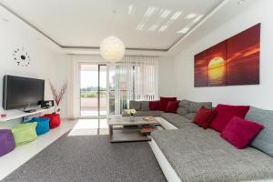 a living room with a couch and a tv at Vila Zatona Sunset with heated swimming pool in Zaton