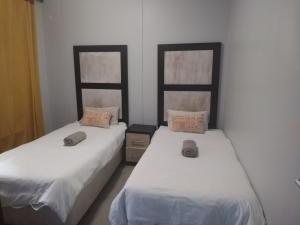 duas camas sentadas uma ao lado da outra num quarto em 504 Coral Reef em La Mercy
