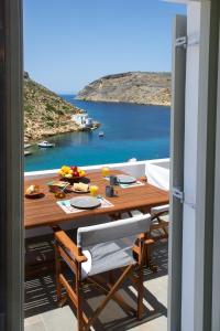 una mesa en un balcón con vistas al océano en Droufakos’ home, Lux seafront apartment w. View, en Sifnos