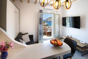 Droufakos’ home, Lux seafront apartment w. View في Sifnos: غرفة معيشة مع طاولة مع وعاء من الفواكه عليها