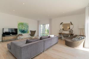 a living room with a couch and a tv at Dune Beach CoLiving in Porto Santo