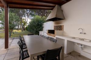 an outdoor kitchen with a large table and chairs at Dune Beach CoLiving in Porto Santo