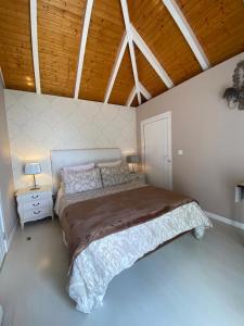 a bedroom with a large bed and a wooden ceiling at Casa de Prazeres in Prazeres