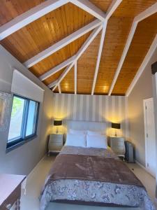 プラゼーレスにあるCasa de Prazeresの木製の天井のベッドルーム1室(大型ベッド1台付)