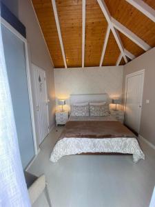 um quarto com uma cama grande e duas mesas de cabeceira em Casa de Prazeres em Prazeres