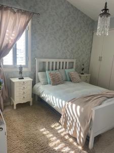 een slaapkamer met een wit bed en een raam bij Pissouri Villa Miramar in Pissouri