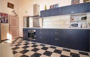 uma cozinha com armários azuis e um piso xadrez em 2 Bedroom Beautiful Home In Avignon em Avignon