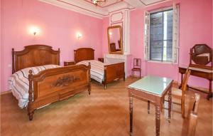 um quarto rosa com 2 camas e uma mesa em 2 Bedroom Beautiful Home In Avignon em Avignon