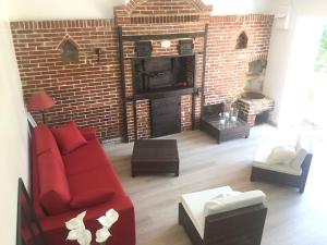 uma sala de estar com um sofá vermelho e uma lareira de tijolos em Maison d'une chambre avec jardin amenage a Huelgoat em Huelgoat