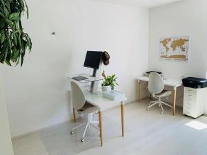 um escritório com duas secretárias e duas cadeiras e um computador em Villa di Design con Giardino e Spa in Cittá em Cuneo