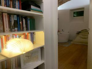 a book shelf filled with books with a lamp on it at Villa di Design con Giardino e Spa in Cittá in Cuneo