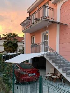 um carro vermelho estacionado em frente a um edifício com uma escada em Villa di Design con Giardino e Spa in Cittá em Cuneo