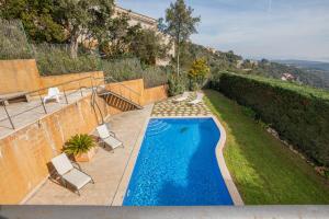 una piscina en un patio con 2 sillas de césped en Hauzify I Villa Masclet, en Castillo de Aro