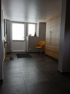 an empty room with a table and a yellow chair at Le gîte des Kritter in Stosswihr