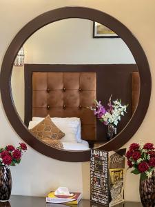 1 dormitorio con espejo grande encima de la cama en Hotel One Swat, en Swat